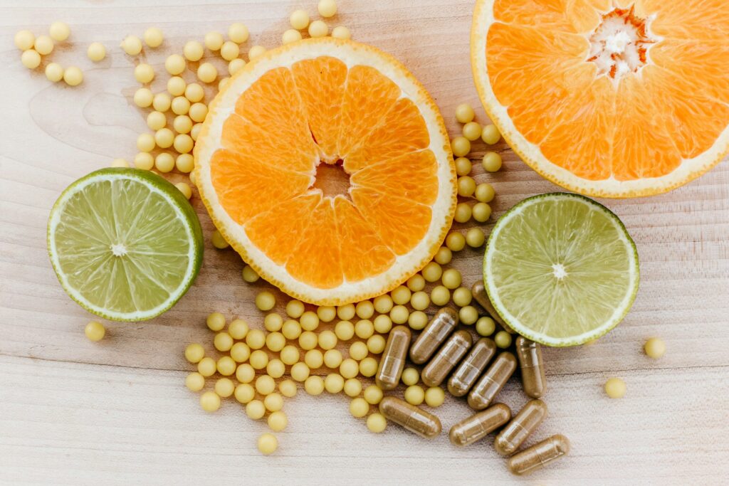 Photo of citrus fruit surrounded by what looks like chick peas and supplement capsules